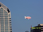 [As the ship arrives, the Sanyo Blimp is hovering around downtown San Diego.]